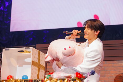 小泉光咲からのプレゼント・ブタの特大クッションを笑顔で抱える武藤潤。（撮影：HannaTAKAHASHI）