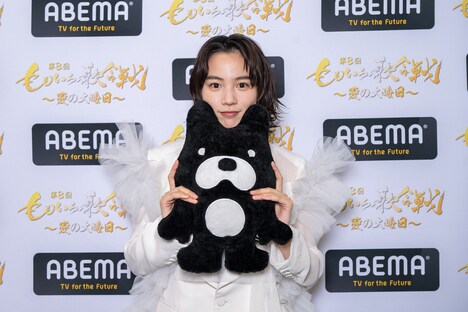 ABEMAのマスコットキャラクター・アベマくんのぬいぐるみを持つのん。