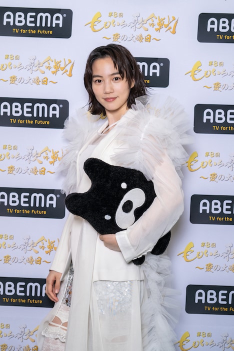 アベマくんをクラッチバッグのように小脇に抱えるのん。