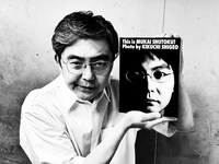 フォトアルバム「This is MUKAI SHUTOKU! Photo by KIKUCHI SHIGEO」を手にする向井秀徳。