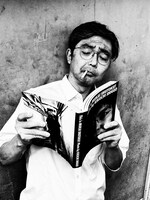 フォトアルバム「This is MUKAI SHUTOKU! Photo by KIKUCHI SHIGEO」を読む向井秀徳。