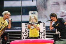 「頭を大きくするマシーン」を装着した鬼龍院翔（中央）。（撮影：菅沼剛弘）