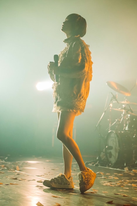 床に積もるアンチコメントの上で歌うano。（撮影：横山マサト）