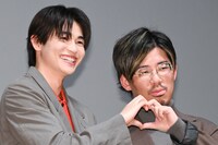 カメラマンからハートポーズを求められ、ともにハートを作る西垣匠（左）、二宮健監督（右）。