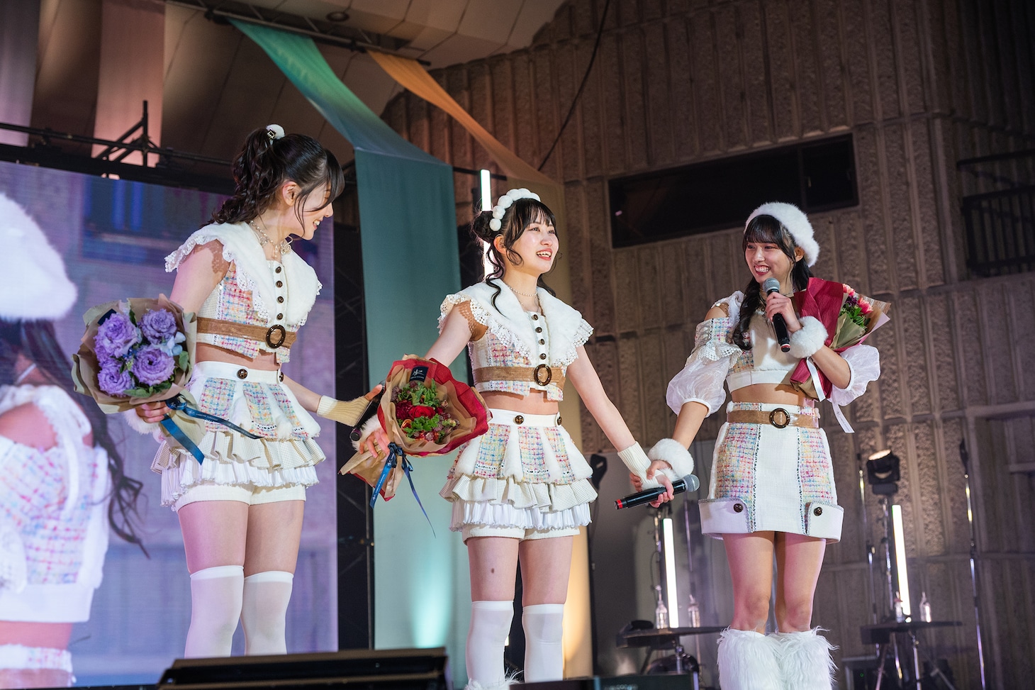 手をつなぐ鶴見萌、中村朱里、清水理子（左から）。