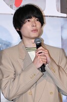 両手でマイクを持つ松村北斗。