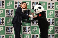 坂本編集長からトロフィーを受け取る阿賀沢紅茶（右）。