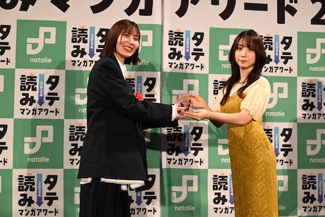 伊織もえからトロフィーを受け取るLINEマンガ広報担当・廣田佳穂氏(左)。