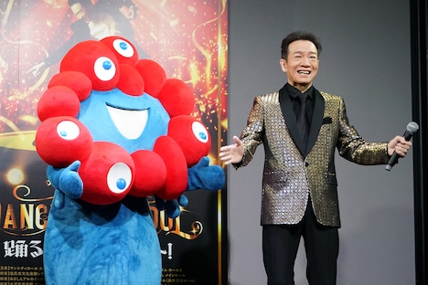 左から2025年日本国際博覧会の公式キャラクター・ミャクミャク、田原俊彦。
