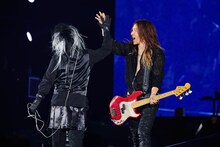 ハイタッチする真矢（Dr）、J（B）。