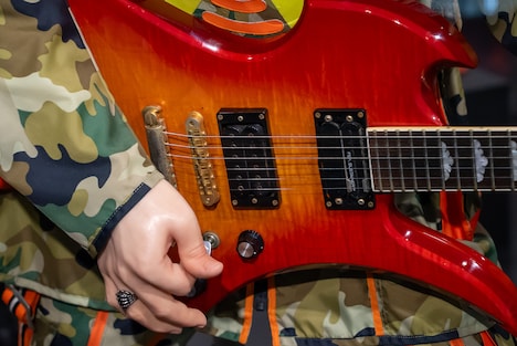 hideリアルヒューマンドールが構えるチェリーサンバーストカラーのフェルナンデス・MG-X。