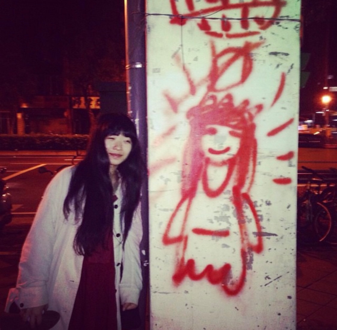 2015年、台北にて。「たぶんお客さんが描いた」グラフィティと一緒に。「台北を訪れるたびに記念撮影してます」
