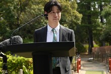 記者からの質問を聞く小袋成彬。