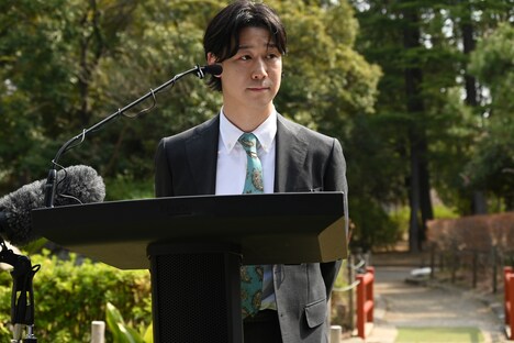 記者からの質問を聞く小袋成彬。