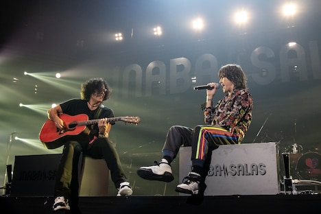 モニタに腰掛けてパフォーマンスする2人。©VERMILLION