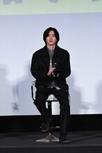 右手にマイク、左手にスマートフォンを持つ道枝駿佑。