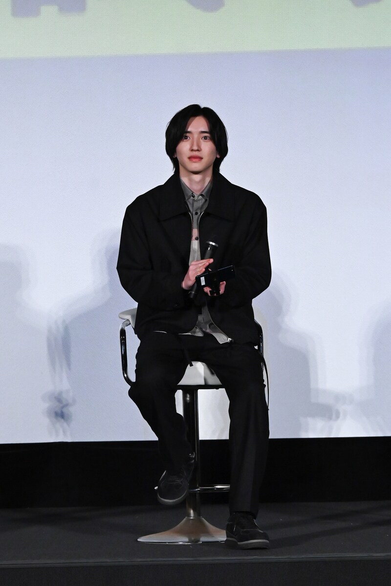 右手にマイク、左手にスマートフォンを持つ道枝駿佑。