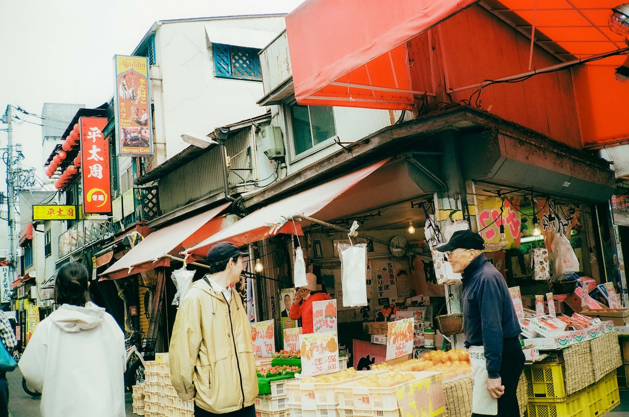 ハーモニカ横丁脇の果実店・一実屋の店主と話す高城晶平。