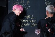 「2025微博文化交流ナイト」のボードにサインする伊藤壮吾（SUPER★DRAGON）。