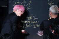 「2025微博文化交流ナイト」のボードにサインする伊藤壮吾（SUPER★DRAGON）。