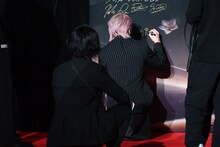 「2025微博文化交流ナイト」のボードにサインするシューヤ（超特急）。