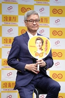 「コラボ記念うちわ」を手にする大倉忠司氏。