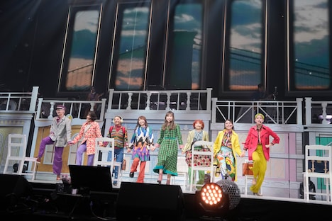 ステージを電車に見立ててパフォーマンスする玉井詩織とアンサンブルキャスト。