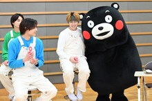 タカシ（中央）になつくくまモン（右）。