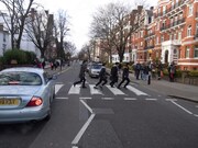 アビーロードスタジオ前の横断歩道にてビートルズ風の写真を撮る玉置周啓ら。