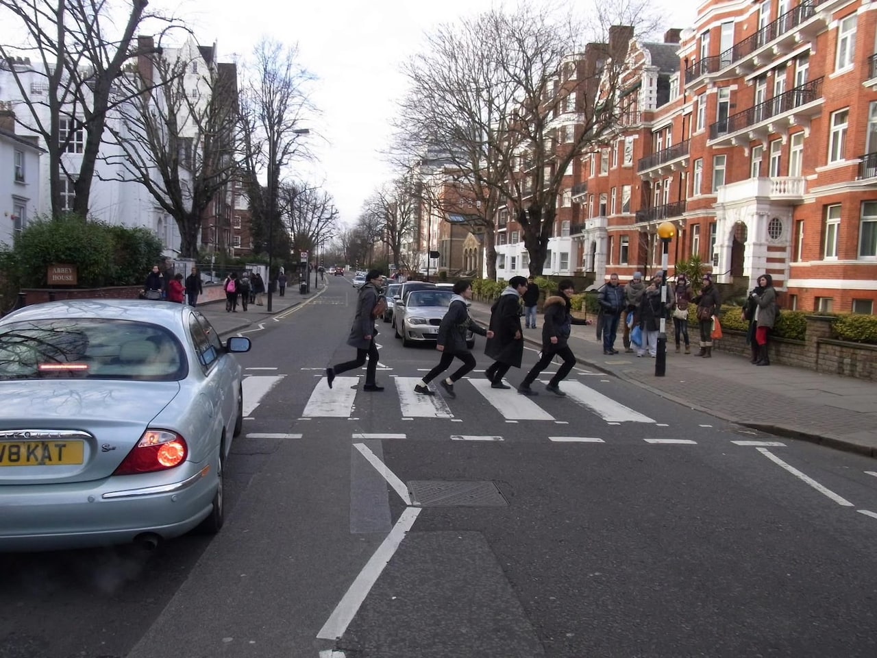 アビーロードスタジオ前の横断歩道にてビートルズ風の写真を撮る玉置周啓ら。