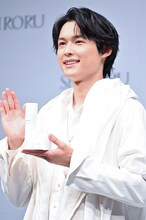 SHIRORU新商品を持って手を振る松村北斗（SixTONES）。