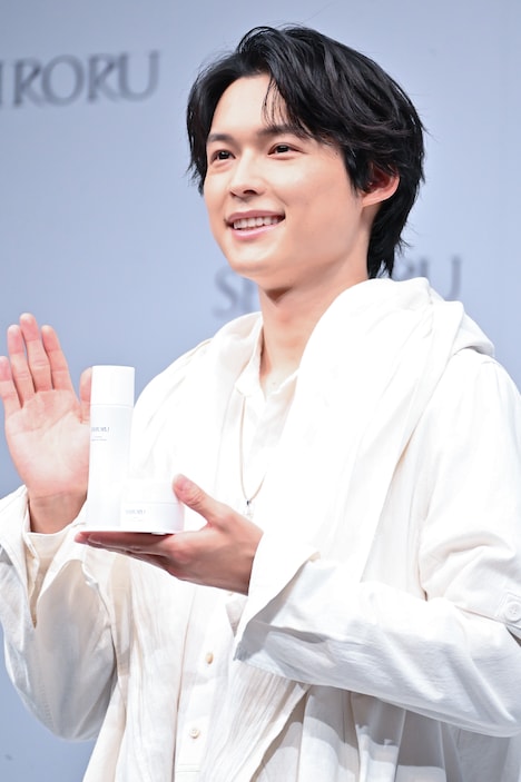 SHIRORU新商品を持って手を振る松村北斗（SixTONES）。