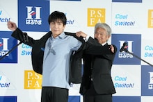 はるやま商事の治山正史会長にジャケットを着せてもらう岩田剛典。