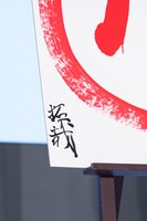 書道でロゴマークの横に記した「拓哉」の文字。