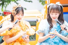 「明治 エッセル スーパーカップ 超バニラ」の蓋を開ける鎮西寿々歌と真中まな。