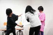 協力しながらTシャツにサインを入れるヤバイTシャツ屋さん。