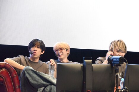 コントローラを置いてくつろぐリョウガ(超特急 / 左)とユーキ(超特急 / 中央)、真面目にプレイする橘柊生(DISH// / 右)。