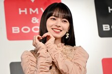 ハートのポーズをする上國料萌衣（アンジュルム）。