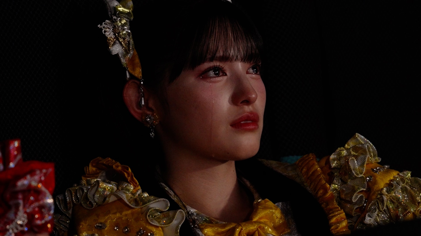 涙を流しながら映画「ドールハウス」を鑑賞する菅田愛貴。©2025 TOHO CO.,LTD.