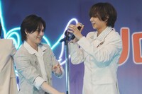 中村海人（右）にマイクスタンドを差し出す松田元太（左）。