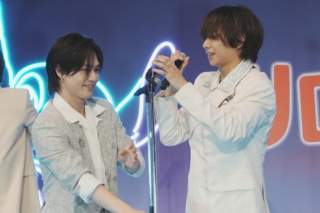 中村海人（右）にマイクスタンドを差し出す松田元太（左）。
