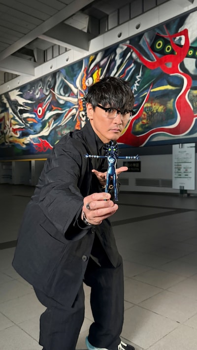 「ブラックタローマン」フィギュアを手にする山口一郎（サカナクション）。