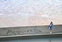 砂浜に「Aqours」と書いた小宮有紗。