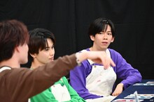 マサヒロ（手前）と会話するリョウガ（奥）。