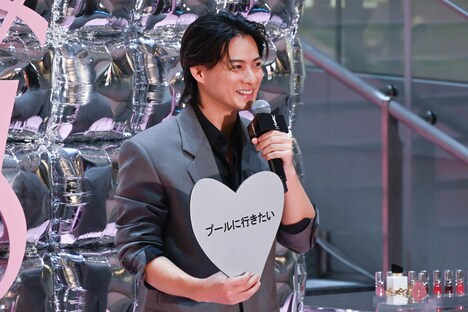「プールに行きたい」というフリップを照れくさそうに見せる平野紫耀。