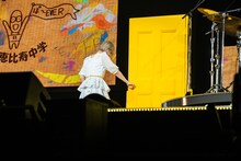 黄色いドアを開ける小林歌穂。