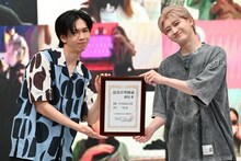 記念日登録証を手に笑顔のリョウガとユーキ。