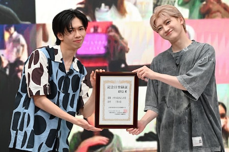 記念日登録証を手に笑顔のリョウガとユーキ。