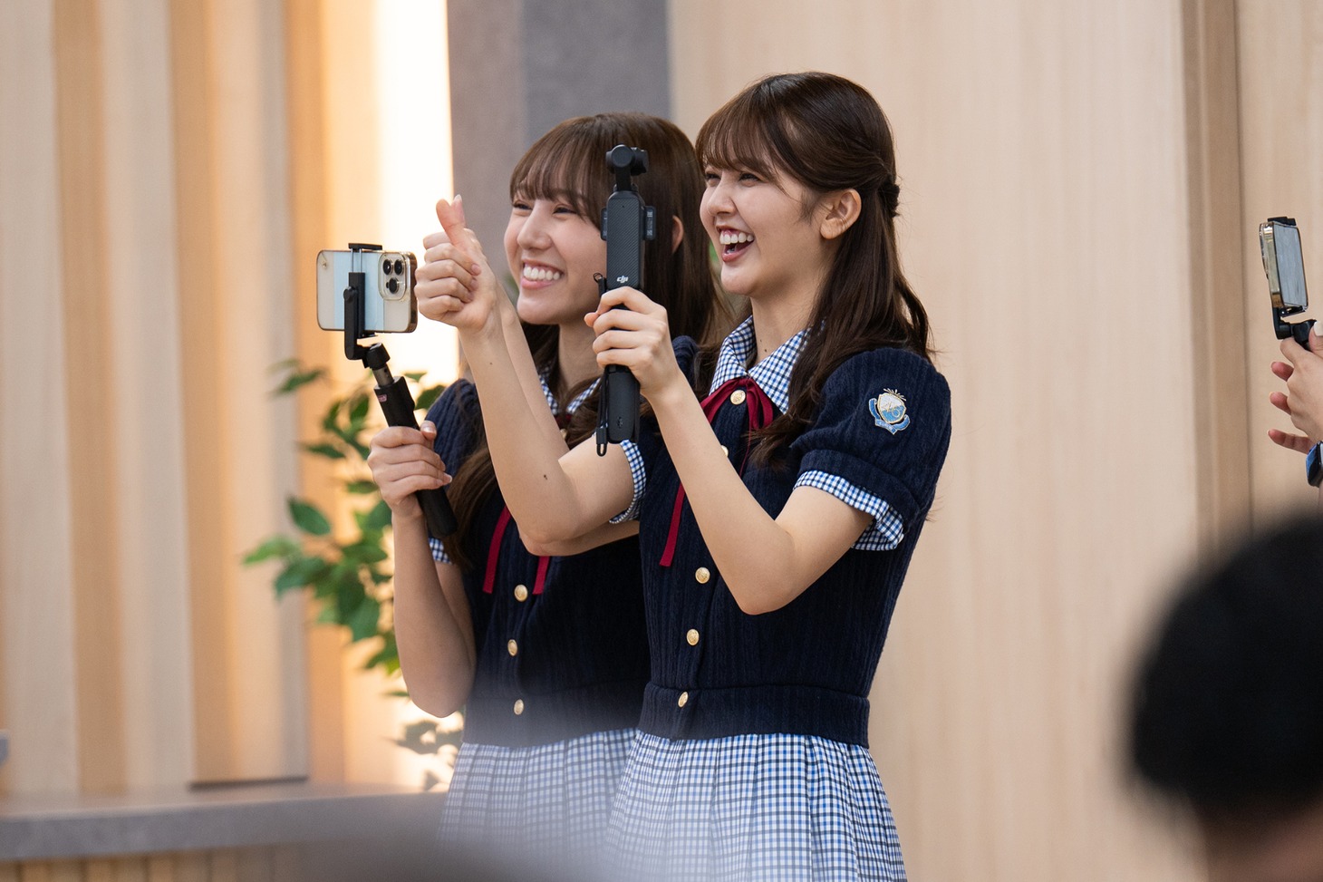 会場後方で会見を見守る日向坂46四期生の平岡海月と山下葉留花。