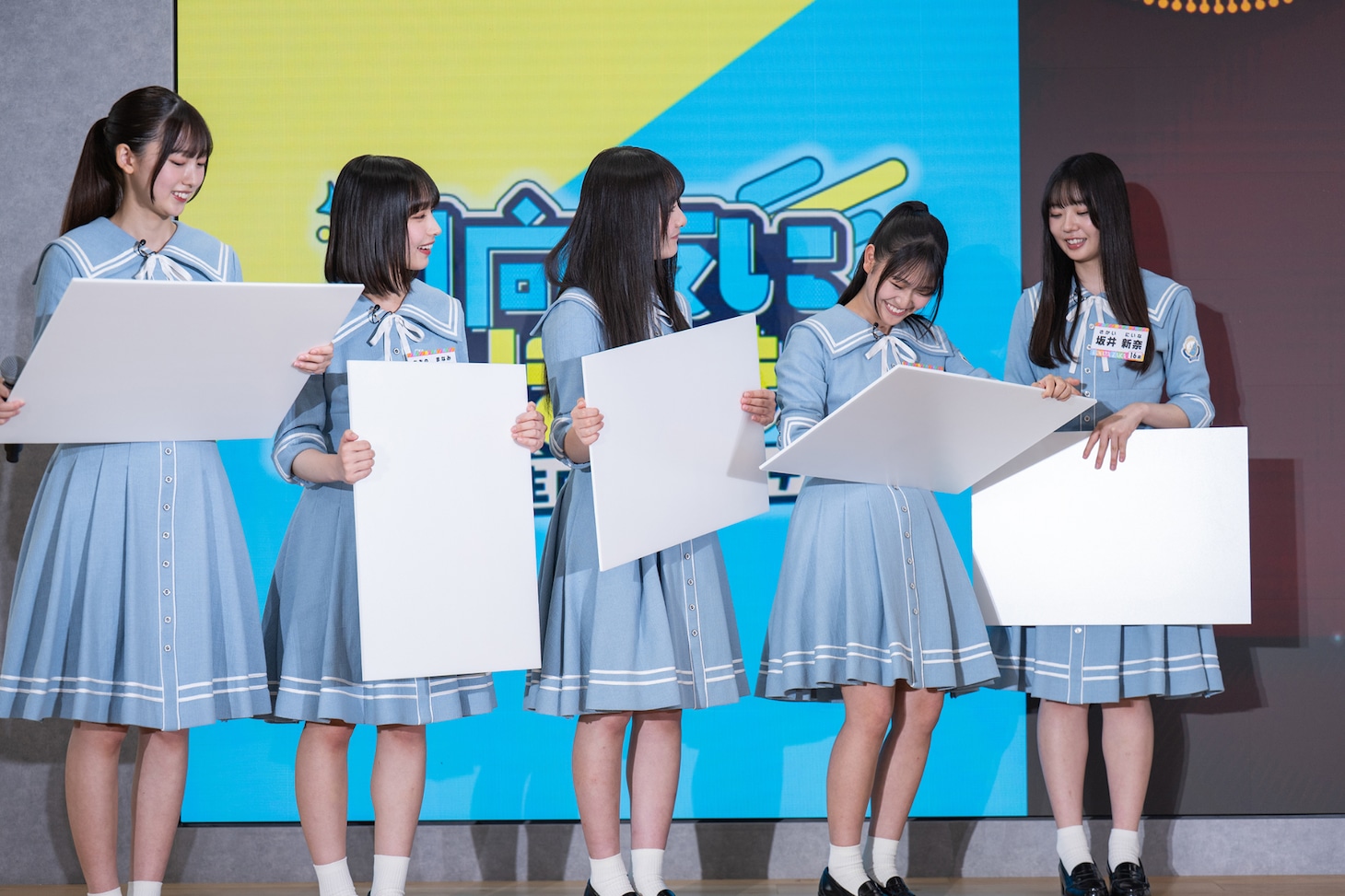 「ひななりクイズ!!」の回答を書き終え、待機中の日向坂46五期生たち。フリップの隠し方で個性が現れる。